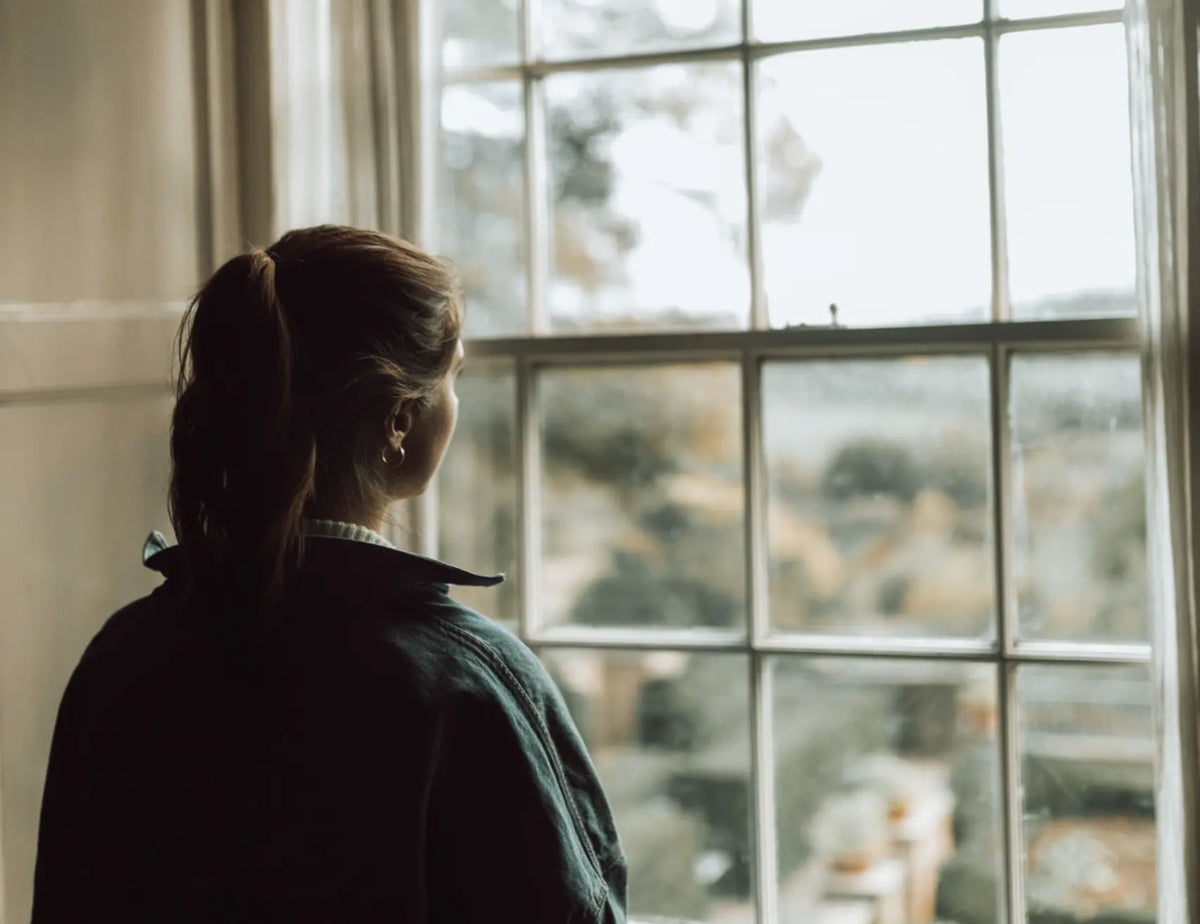 A person looking toward a bright window with a calm hopeful expression — microdosing depression anxiety